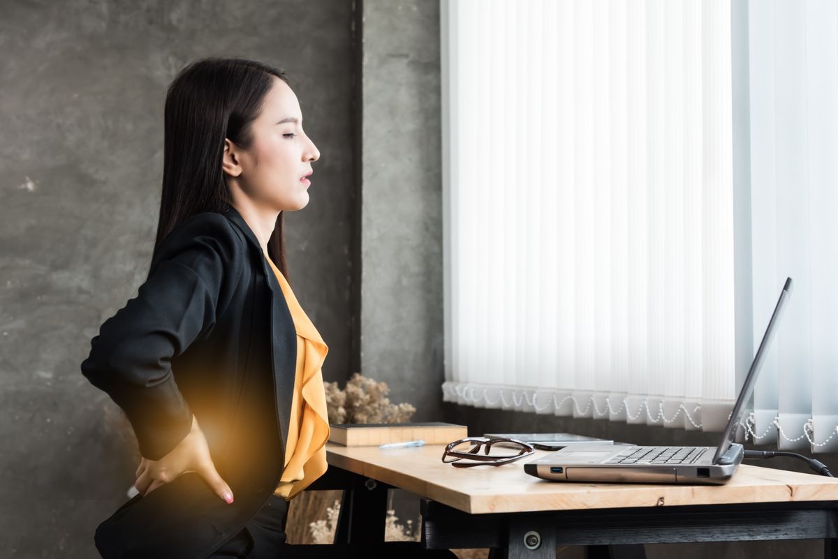 Image of young office woman  back pain while sitting at working desk,concept office syndrome.